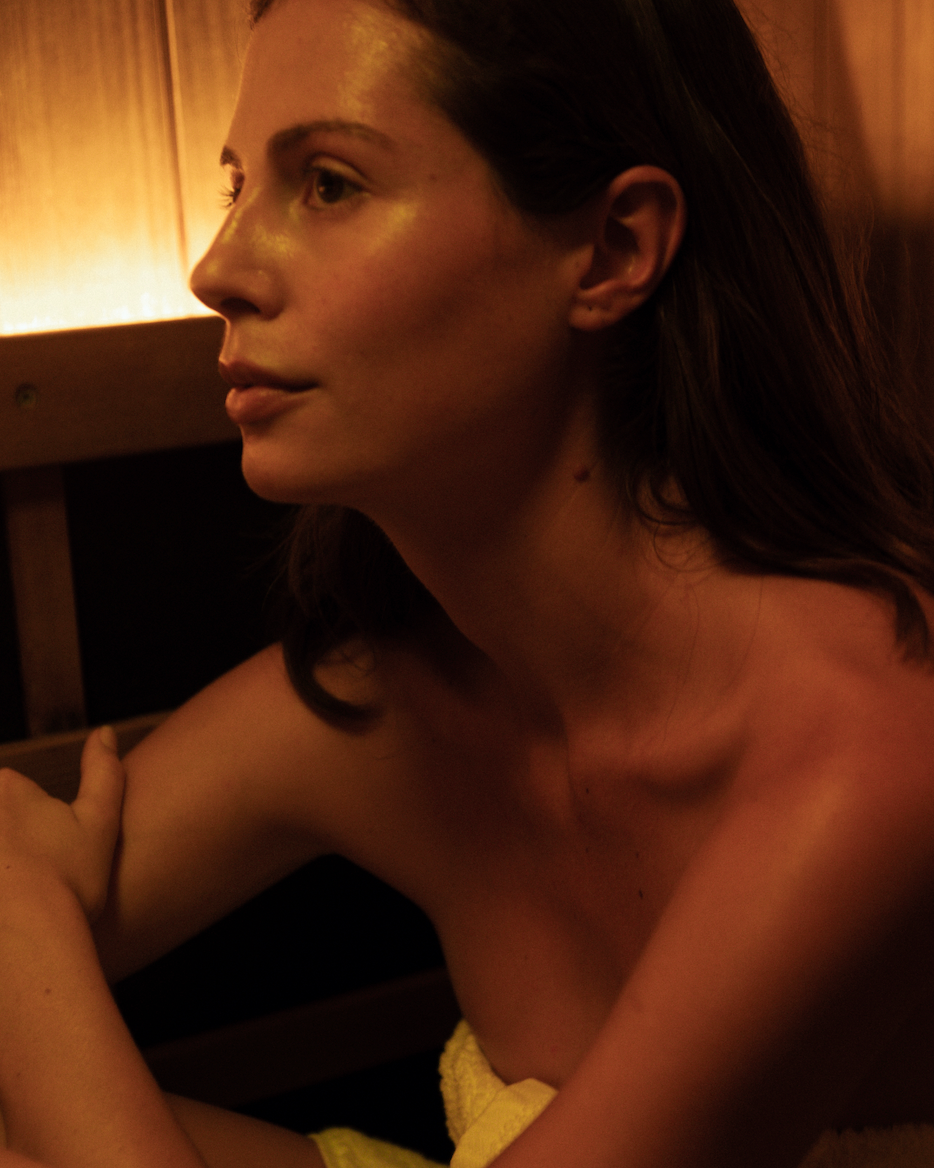 Woman sitting in a dimly lit room with a warm glow