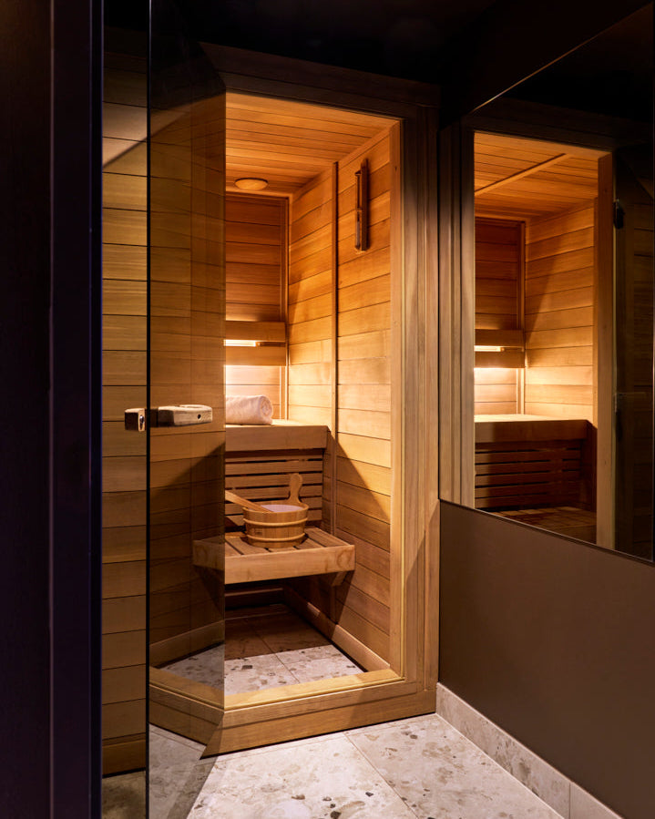 Interior of a wooden sauna with a stone floor.