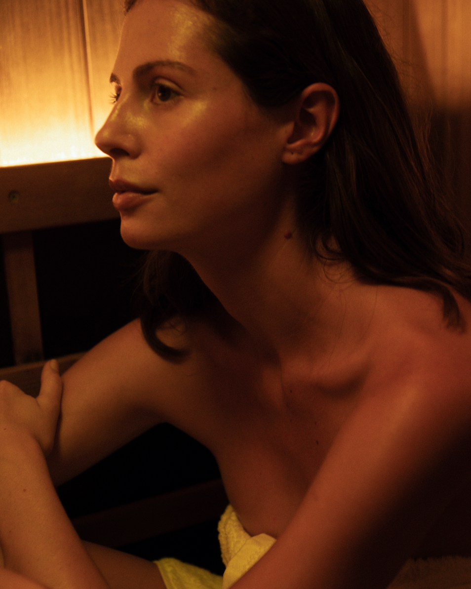Woman sitting in a sauna with a warm glow