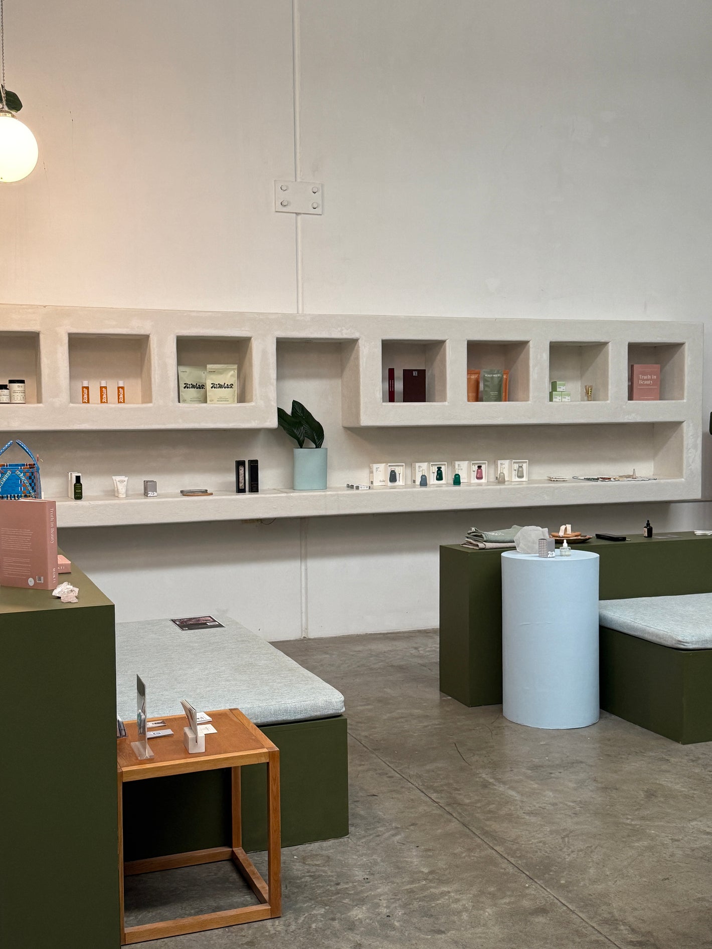 Reception area at Nimbus Co Byron Bay wellness studio, featuring a modern minimalist interior with seating, product displays, and retail shelves in Byron Bay NSW.

